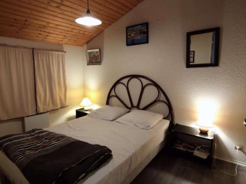 une chambre avec un grand lit avec deux lampes dans l'établissement Appartement près de la plage, balcon et parking gratuit - FR-1-778-2, à Dolus-d'Oléron
