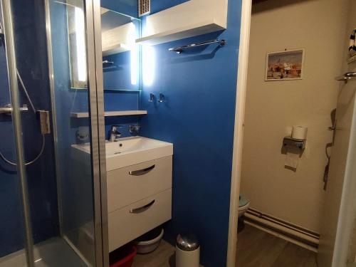 La salle de bains bleue est pourvue d'un lavabo et d'une douche. dans l'établissement Appartement près de la plage, balcon et parking gratuit - FR-1-778-2, à Dolus-d'Oléron