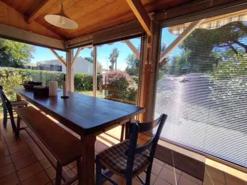 une salle à manger avec une table et une grande fenêtre dans l'établissement Maison lumineuse proche plage avec jardin, véranda et stationnement - FR-1-778-13, à Saint-Georges-dʼOléron