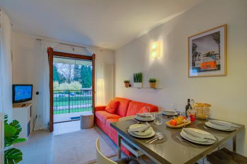 sala de estar con sofá naranja y mesa en Lenni Apart Swimming Pool and lake - Happy Rentals, en Leggiuno