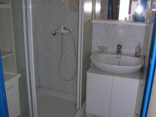 uma casa de banho com um lavatório, um chuveiro e um lavatório. em Appartement Valras-Plage, 3 pièces, 4 personnes - FR-1-781-12 em Valras-Plage