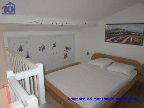 a bedroom with a white bed and a staircase at Maison Valras-Plage, 2 pièces, 6 personnes - FR-1-781-18 in Valras-Plage