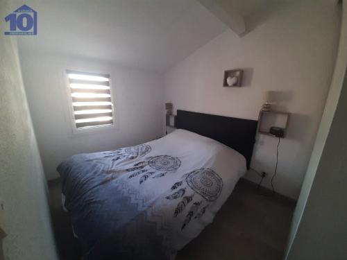 um quarto com uma cama num pequeno quarto em Maison Vendres, 2 pièces, 5 personnes - FR-1-781-27 em Vendres
