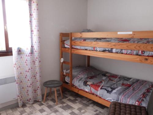 1 Schlafzimmer mit 2 Etagenbetten und einem Stuhl in der Unterkunft Maison La Tranche-sur-Mer, 3 pièces, 4 personnes - FR-1-194-279 in La Tranche-sur-Mer