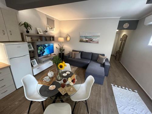 Karydakis Properties في مدينة زاكينثوس: غرفة معيشة مع أريكة زرقاء وطاولة
