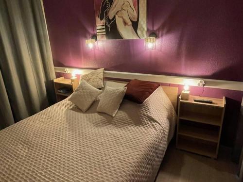 a bedroom with a bed with a purple wall at Charmant F2 avec terrasse de 25m² et parking, proche Thermes à Balaruc-les-Bains - FR-1-680-42 in Balaruc-les-Bains