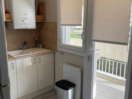 a small kitchen with a sink and a window at Charmant F2 avec terrasse de 25m² et parking, proche Thermes à Balaruc-les-Bains - FR-1-680-42 in Balaruc-les-Bains