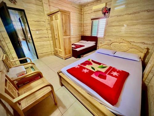 a bedroom with a bed and two chairs in it at Nhà Nghỉ Thanh Thuý in Quang Tri