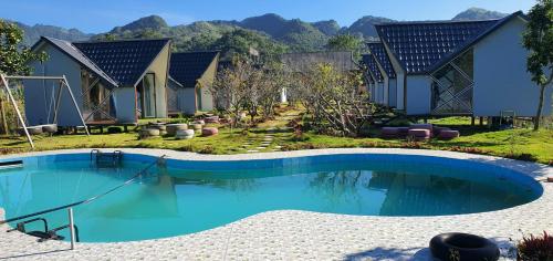 uma piscina em frente a uma casa com montanhas em Homstay Mimosa Mộc Châu em Mộc Châu