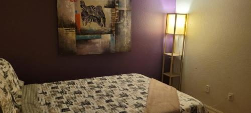 a bedroom with a bed and a painting on the wall at Be our Guest - Shared Home Lancaster in Palmdale