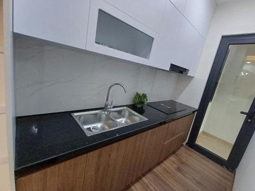 a kitchen with a sink and a tv on the wall at Mami House - Luxcity Cẩm Phả Serviced Apartments in Cẩm Phả