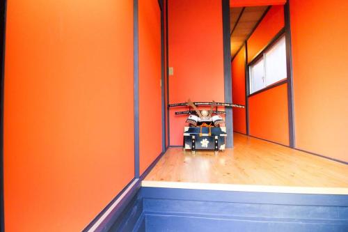 un niño sentado en una carreta en una habitación naranja en SAMURAI HOUSE Yokohama, en Yokohama