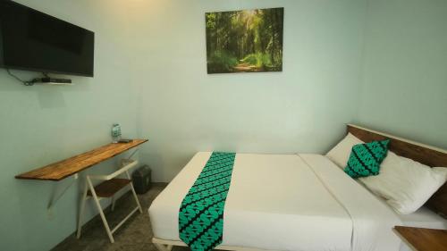 - une chambre avec un lit et une télévision à écran plat dans l'établissement Kalimaya Residence Syariah 1 by Cocotel, à Brumbung