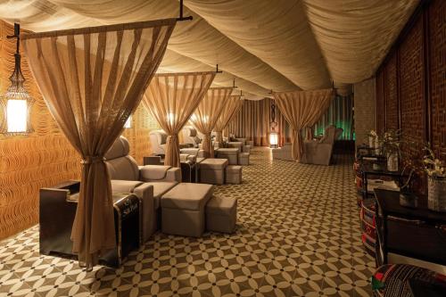 a large room with couches and chairs and curtains at Silk Path Grand Sapa Resort & Spa in Sa Pa
