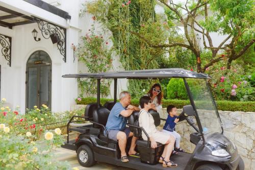 a woman and family sitting in a golf cart at Silk Path Grand Sapa Resort & Spa in Sa Pa