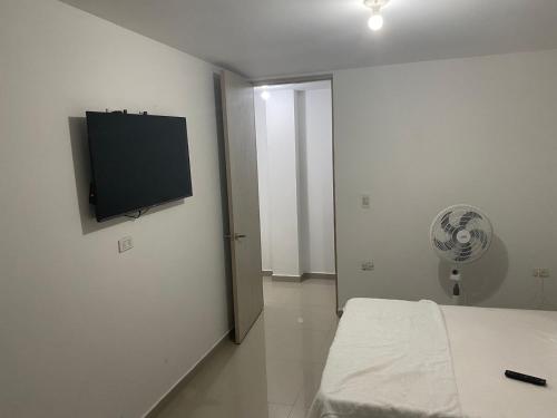 Schlafzimmer mit einem Bett und einem Flachbild-TV an der Wand in der Unterkunft HOTEL IBIZA in Valledupar