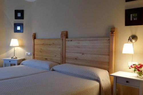 2 Betten in einem Schlafzimmer mit 2 Lampen und Blumen in der Unterkunft 5 bedrooms house with wifi at Molinaseca in Molinaseca