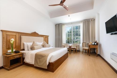 a hotel room with a bed and a television at Araliya Red in Nuwara Eliya