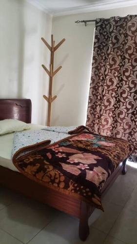 ein Bett mit einer Decke auf dem Zimmer in der Unterkunft Cozy Homes Shared 1 in Kigali