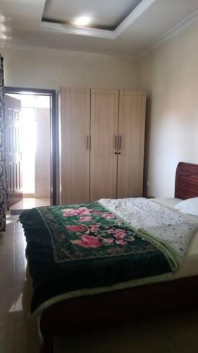 ein Schlafzimmer mit einem Bett und einem Schrank mit Blumen darauf in der Unterkunft Cozy Homes Shared 1 in Kigali