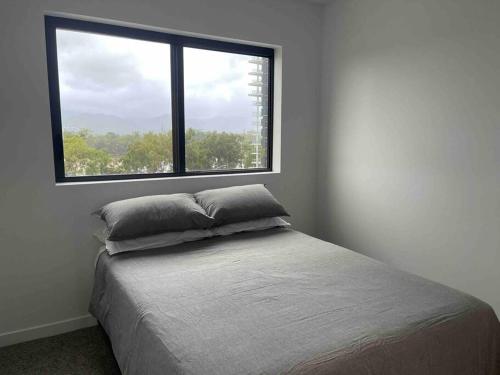 a bed with two pillows in a room with a window at Loft Rockhampton in Rockhampton