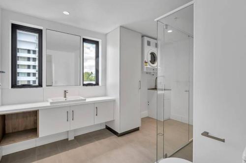a white bathroom with a sink and a shower at Loft Rockhampton in Rockhampton