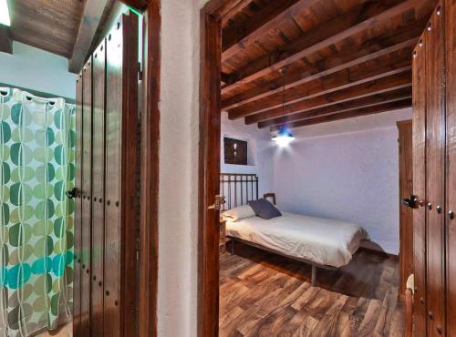 een slaapkamer met een bed in een kamer met houten balken bij 6 bedrooms house with shared pool jacuzzi and wifi at Montefrio in Montefrío