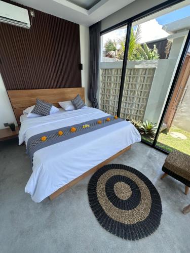 sypialnia z dużym łóżkiem i dużym oknem w obiekcie Bali Bird Villa Canggu w mieście Dalung