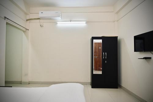 a white room with a black door and a tv at Queen's Residency in Guwahati