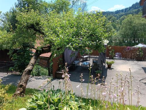a garden with a tree and a table and chairs at "Dom Pod Grzybkiem" in Krościenko