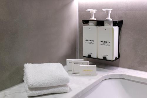 Baño con 2 botellas de jabón y toallas en un lavabo en Veriu Macquarie Park, en Sídney