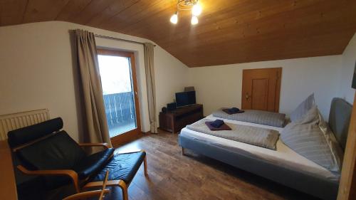 um quarto com uma cama, uma cadeira e uma janela em Chiemsee-Ferienhaus Schlegel em Breitbrunn am Chiemsee