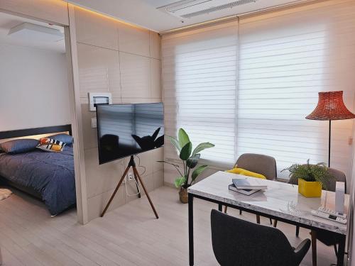 a living room with a bed and a table in a room at 서울의 야경이 멋진 옐로우 하우스 in Seoul