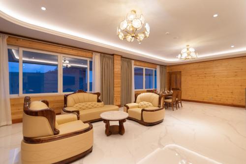 a living room with couches and chairs and a table at Araliya Red - Budget friendly Hotel- Where you find stunning 360 panoramic view of Nuwara Eliya in Nuwara Eliya