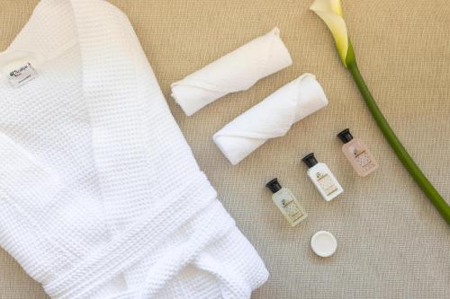 a white shirt and some medicines and a flower at Araliya Red - Lean Luxury - Where you find stunning 360 panoramic view of Nuwara Eliya in Nuwara Eliya