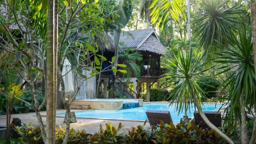 a swimming pool in a resort with palm trees at Garden Chalets Koh Lanta in Krabi town