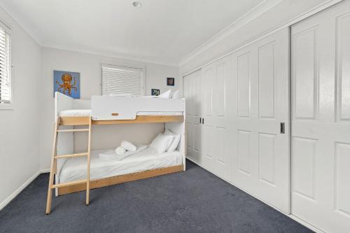 a bedroom with a bunk bed and a ladder at Pacific Blue, Gerringong in Gerringong