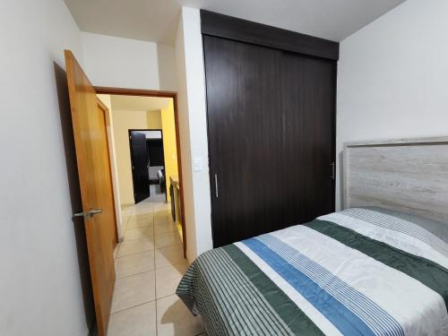 1 dormitorio con 1 cama y puerta que da a un pasillo en Casa Descanso de Mamá, en San Luis Potosí