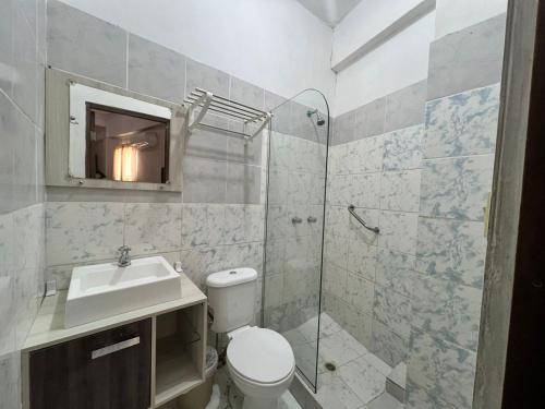 a bathroom with a toilet and a sink and a shower at Atlantic Suites Hotel in Guayaquil