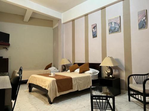 ein Schlafzimmer mit einem Bett, einem Sofa und einem Stuhl in der Unterkunft Atlantic Suites Hotel in Guayaquil