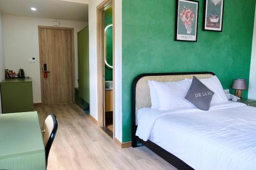 a bedroom with a bed with a green wall at De La Sol Villa Dalat in Da Lat