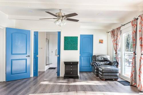 a living room with blue doors and a chair at Modern LakeHouse Sleeps 20 Hot Tub/Games/Fire Pit in Oakhurst