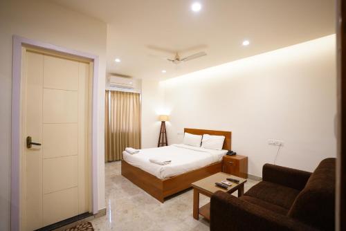 a hotel room with a bed and a couch at THE EKAH COMFORTS in Bangalore