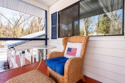 a porch with a wicker chair and a table at Modern LakeHouse Sleeps 20 Hot Tub/Games/Fire Pit in Oakhurst
