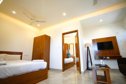 a bedroom with a bed and a television in it at THE EKAH COMFORTS in Bangalore