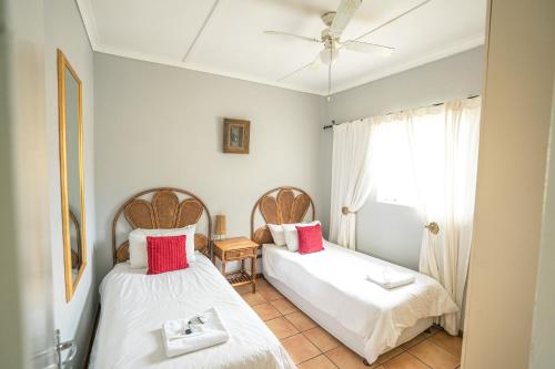 a bedroom with two beds and a window at Olive Grove Guest Farm in Beaufort West