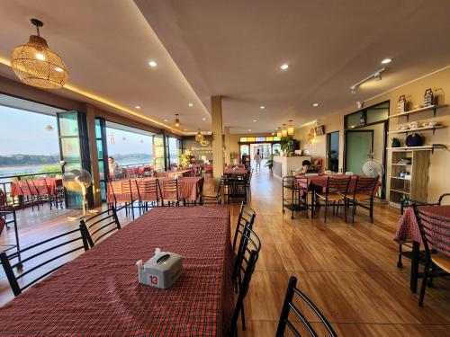um restaurante com mesas e cadeiras num quarto em Suksomboonhotel em Loei