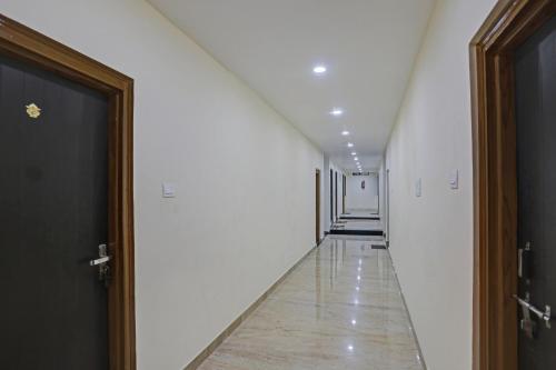 a hallway with white walls and a long hallway with doors at OYO Flagship J.d.p Guest House in Varanasi