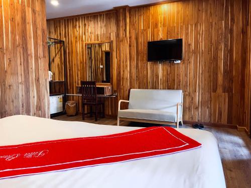 ルアンパバーンにあるLuang Prabang Villa Oasisのベッドルーム(ベッド1台、椅子、テレビ付)