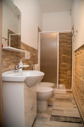 a bathroom with a sink and a toilet and a shower at Aliga in Alghero